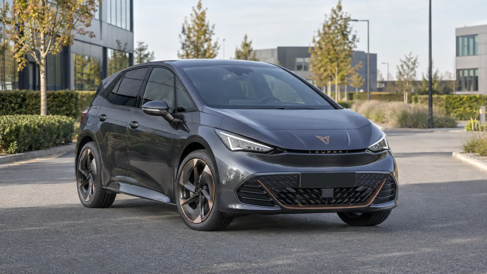 Grijze CUPRA Born bij een modern bedrijfspand