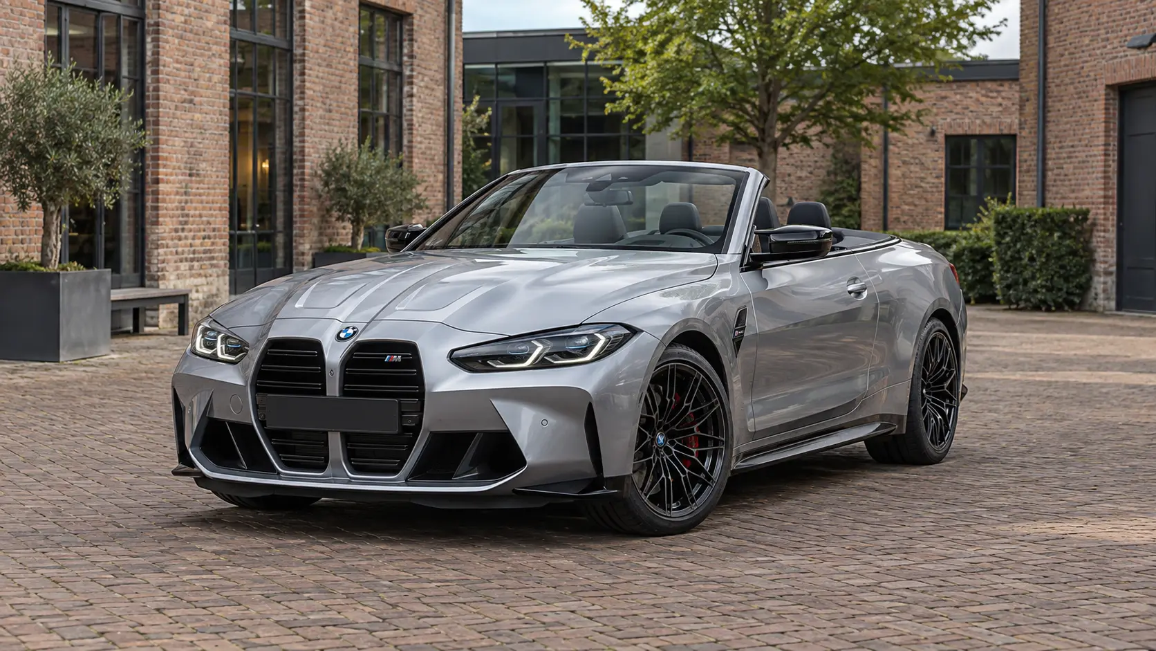 Zilvergrijze BMW M4 Competition Cabrio G83 met geopend dak