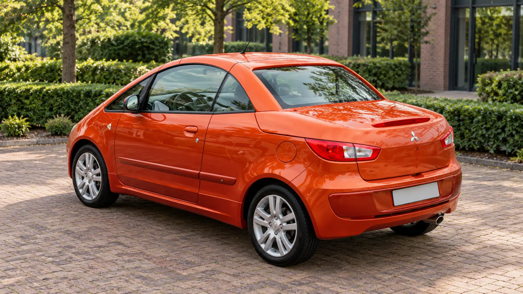 Oranje Mitsubishi Colt CZC met gesloten dak van achteren gezien