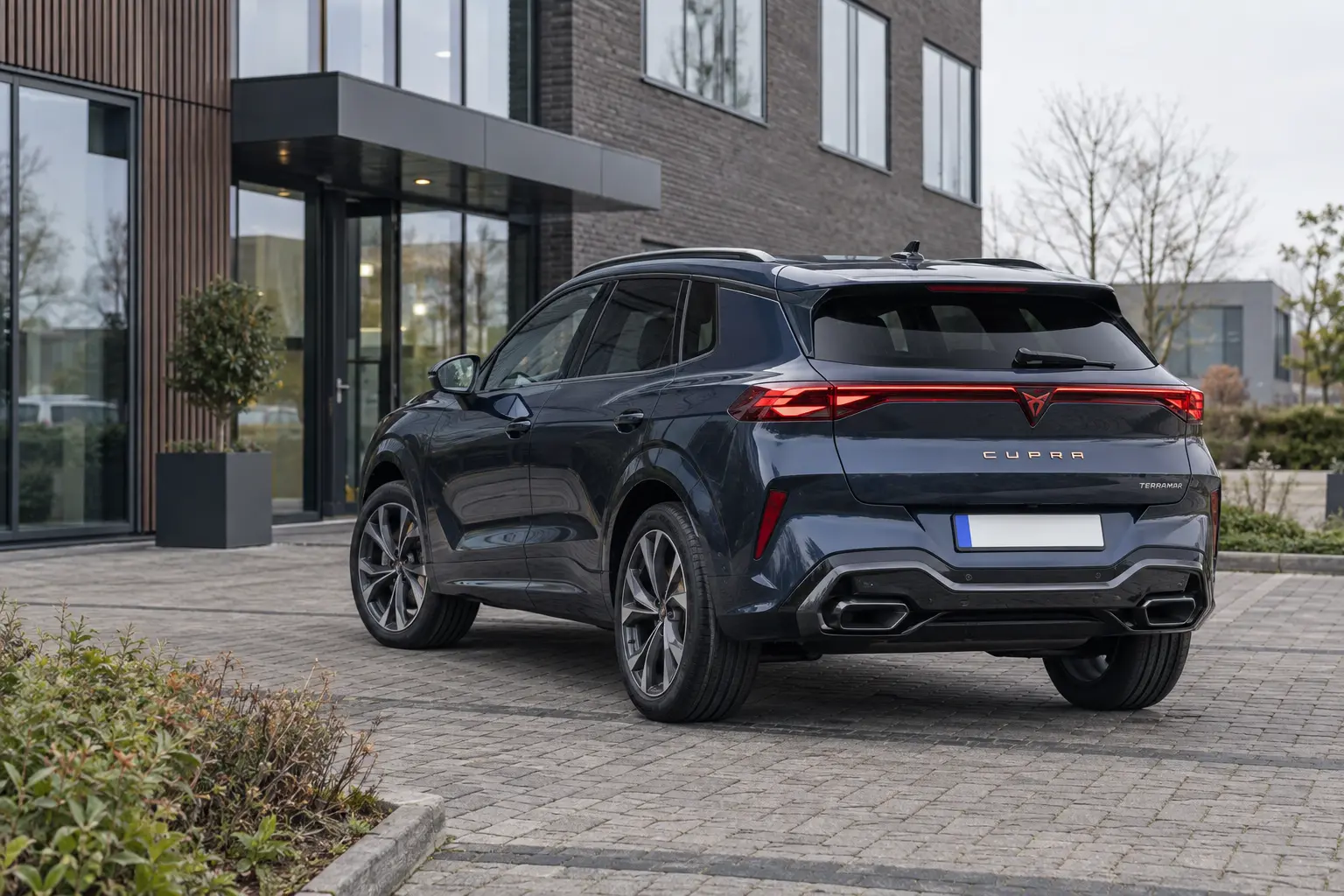 CUPRA Terramar 1.5 eTSI geparkeerd voor een modern Nederlands kantoorgebouw