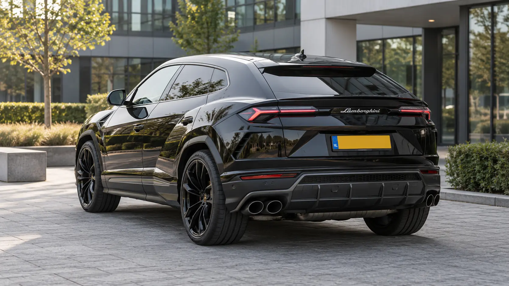 Zwarte oorspronkelijke Lamborghini Urus V8 van achteren bij een moderne bedrijfslocatie