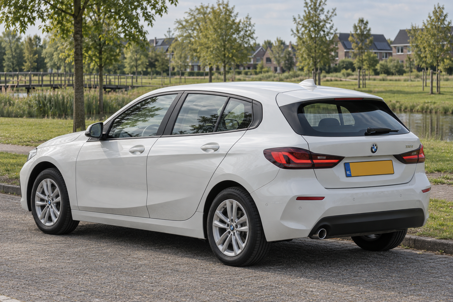 Witte BMW 1 Serie F40 vijfdeurs, schuin van achteren op een parkeerplaats
