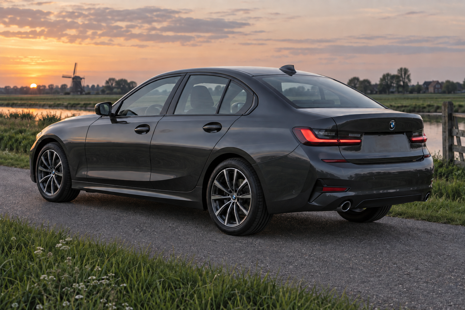 Grijze BMW 3 Serie Sedan bij een Nederlandse polderweg