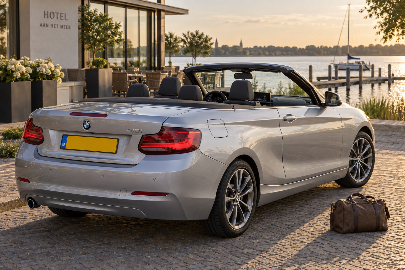 Zilverkleurige BMW 2 Serie Cabrio F23 met geopend stoffen dak en vier zitplaatsen bij een Nederlandse laan