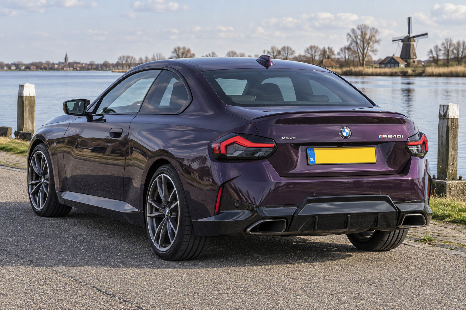 Paarse BMW 2 Serie Coup&eacute; G42 M240i met twee deuren, gezien van achteren bij een modern kantoor