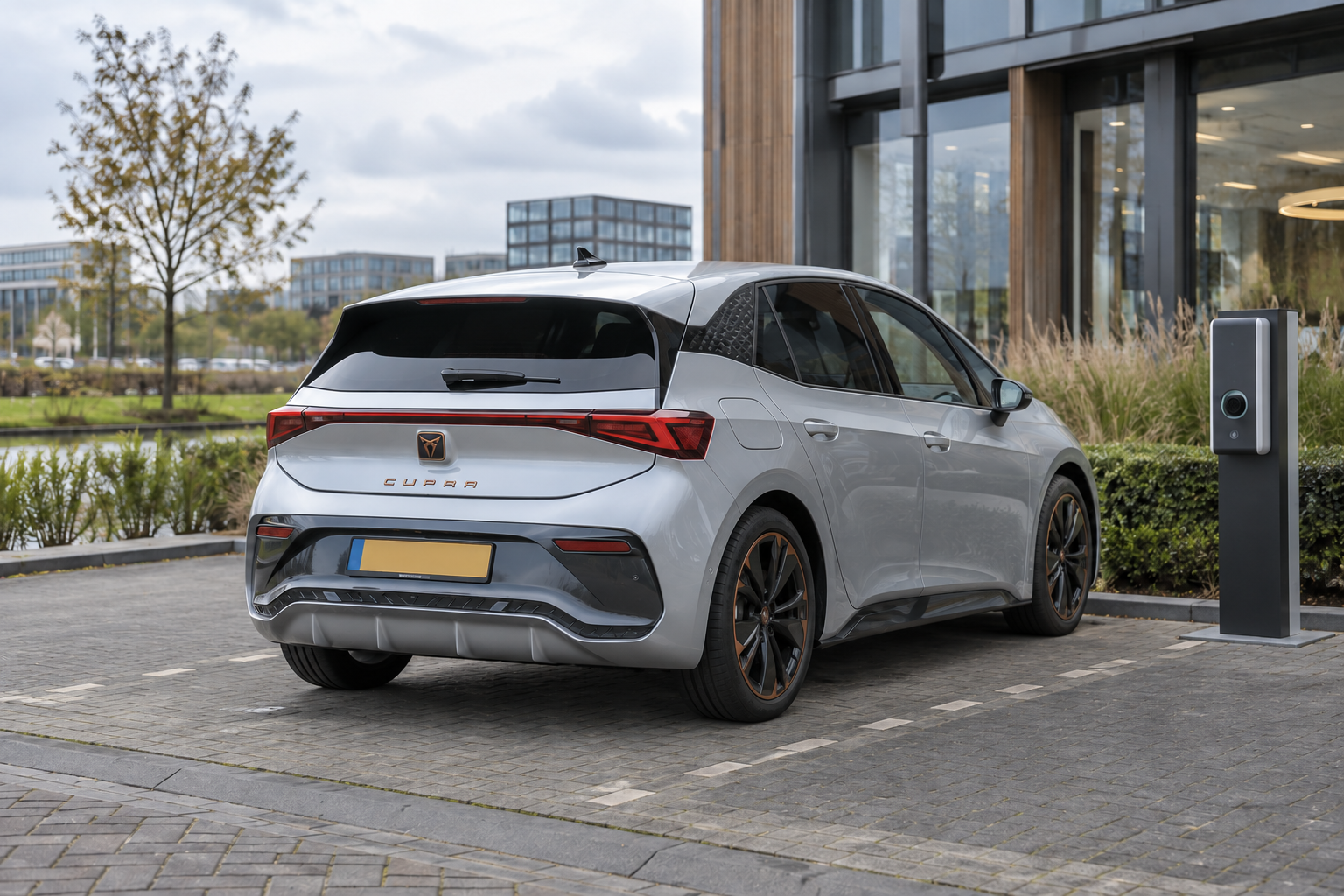 CUPRA Born bij een laadpunt naast een kantoor