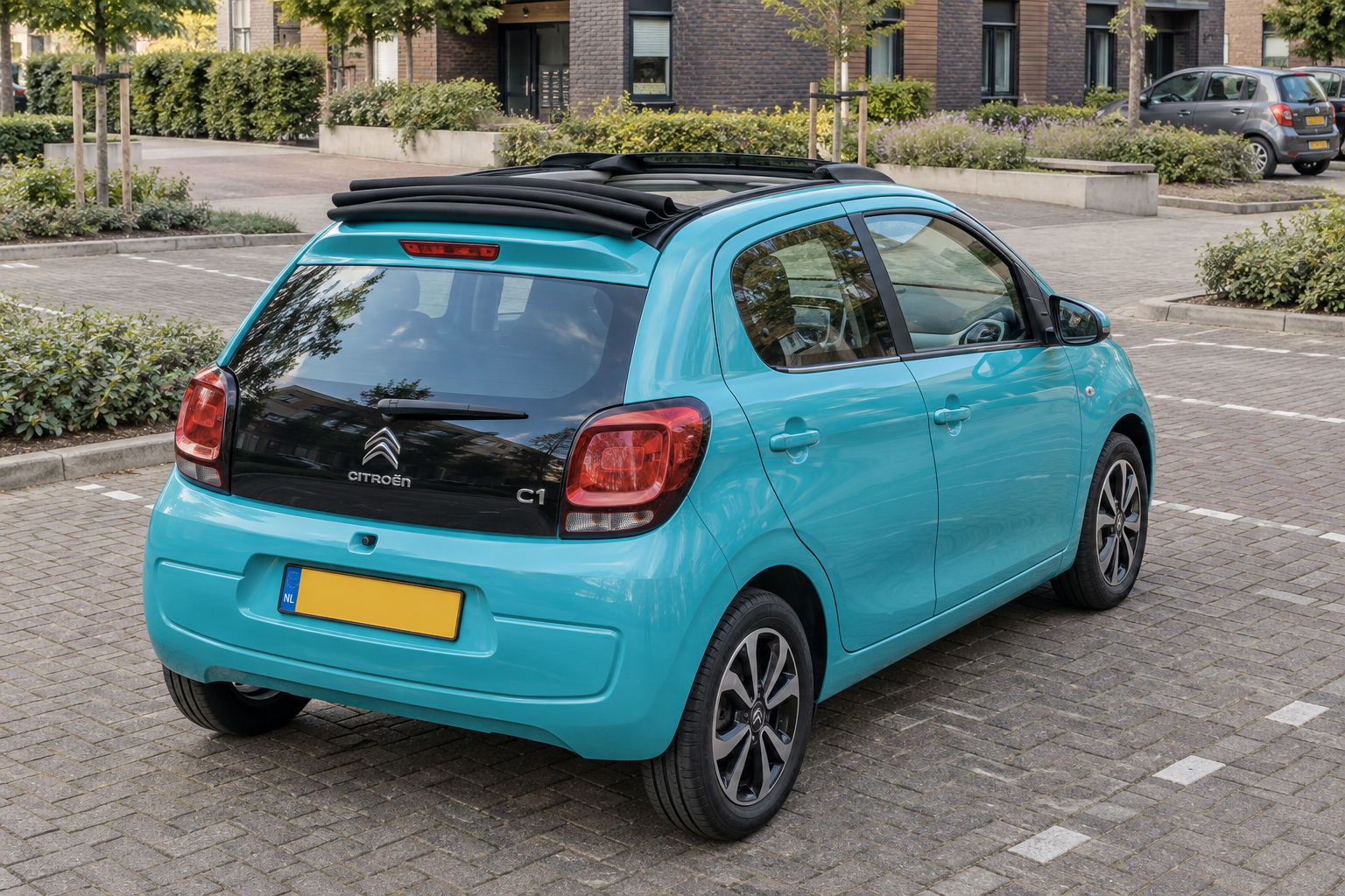 Turquoise Citro&euml;n C1 Airscape met geopend stoffen vouwdak, van achteren gezien