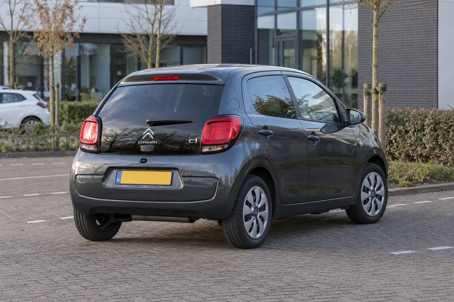 Grijze Citro&euml;n C1 vijfdeurs met gesloten dak, van achteren gezien