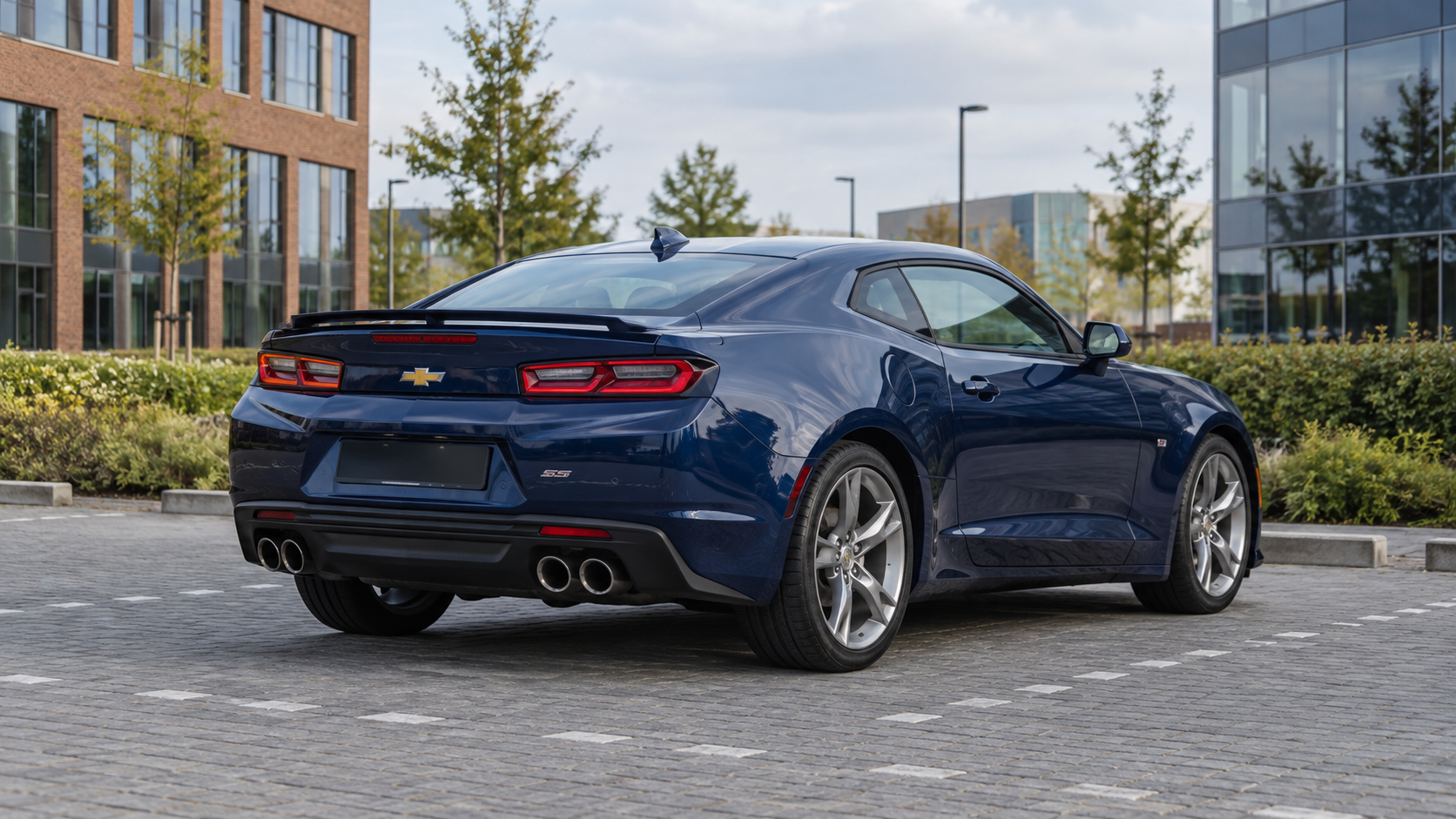 Blauwe Chevrolet Camaro coup&eacute; van achteren bij een bedrijfspand