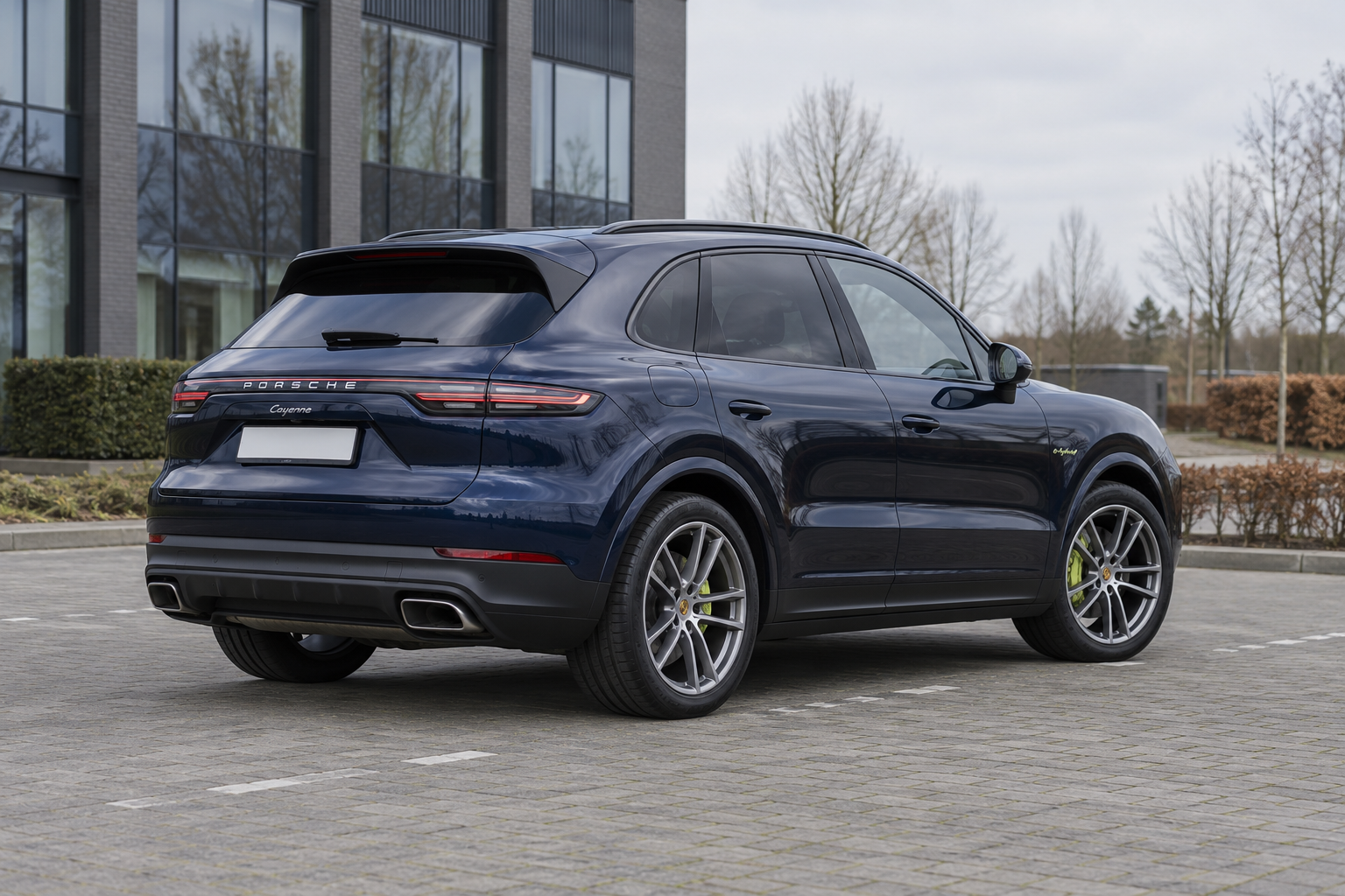 Porsche Cayenne E-Hybrid SUV gezien van opzij bij een parkeerplaats