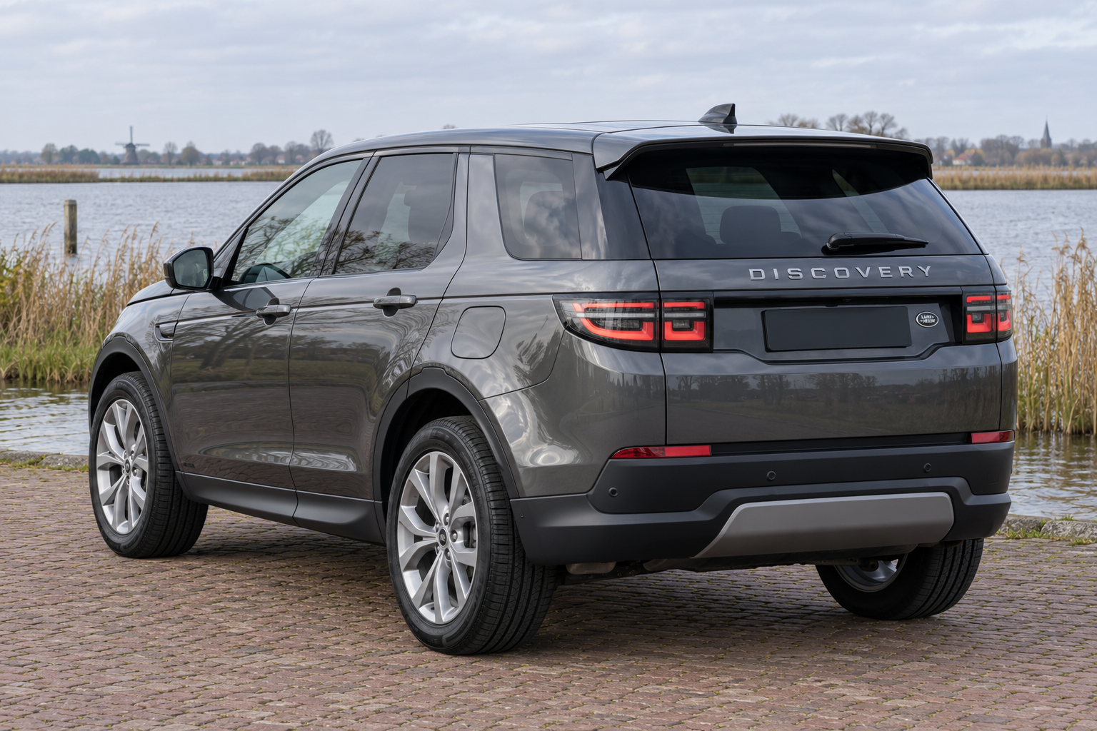 Donkergrijze Discovery Sport van achteren als PHEV-modelillustratie, zonder individuele uitvoering of accutoestand te claimen