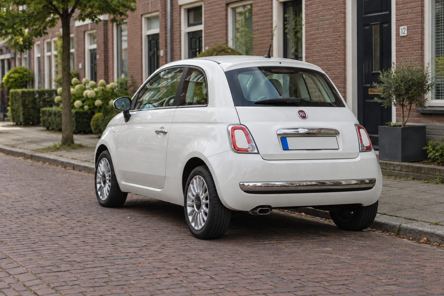 Fiat 500 van de eerdere generatie met Hybrid-aandrijving geparkeerd in een Nederlandse woonstraat