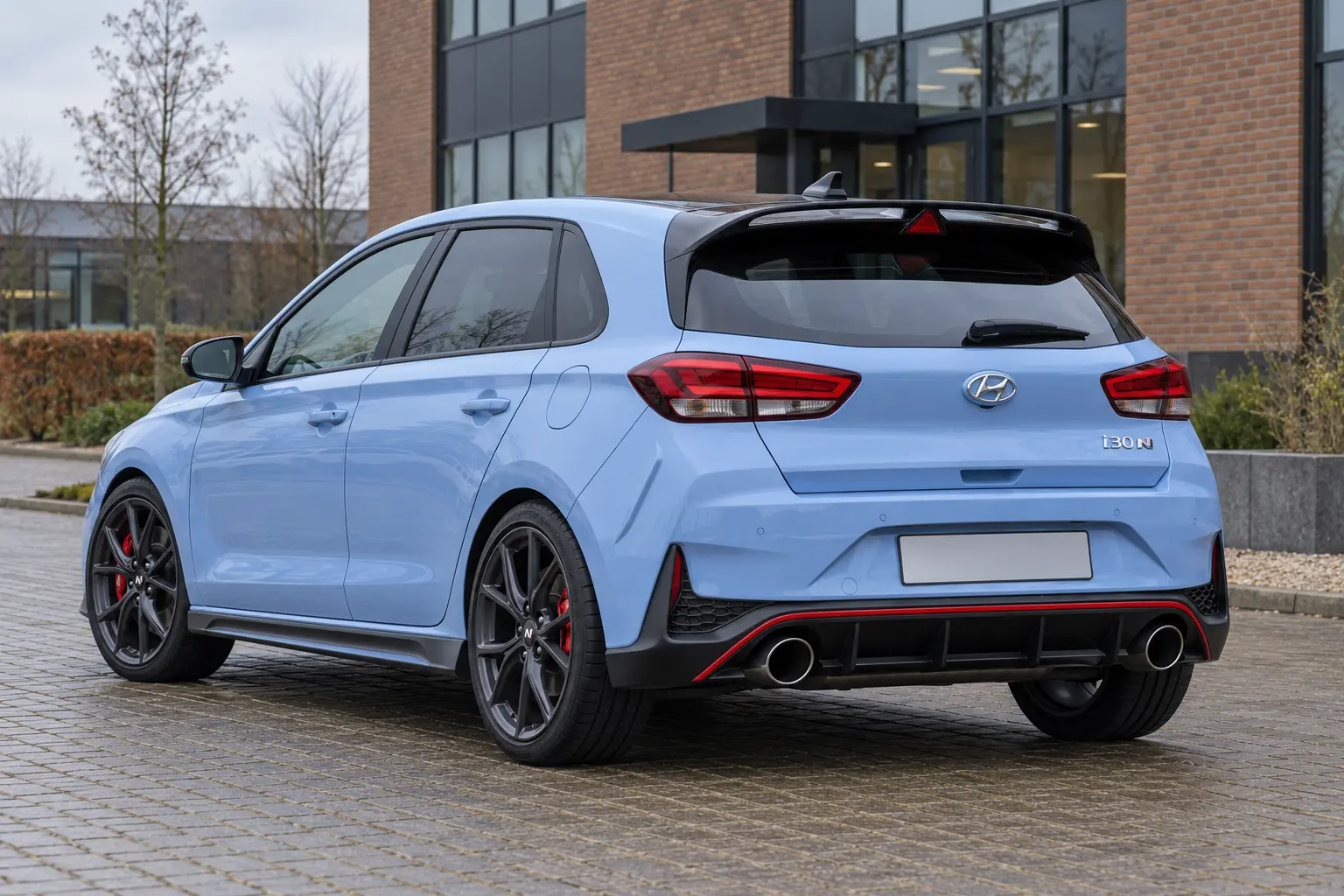 Illustratieve vernieuwde i30 N-hatchback met dakspoiler, rode onderrand en twee ronde uitlaten; geen Fastback