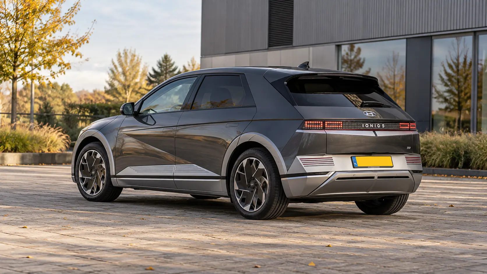 Grijze Hyundai IONIQ 5 van achteren op een zakelijke parkeerplaats