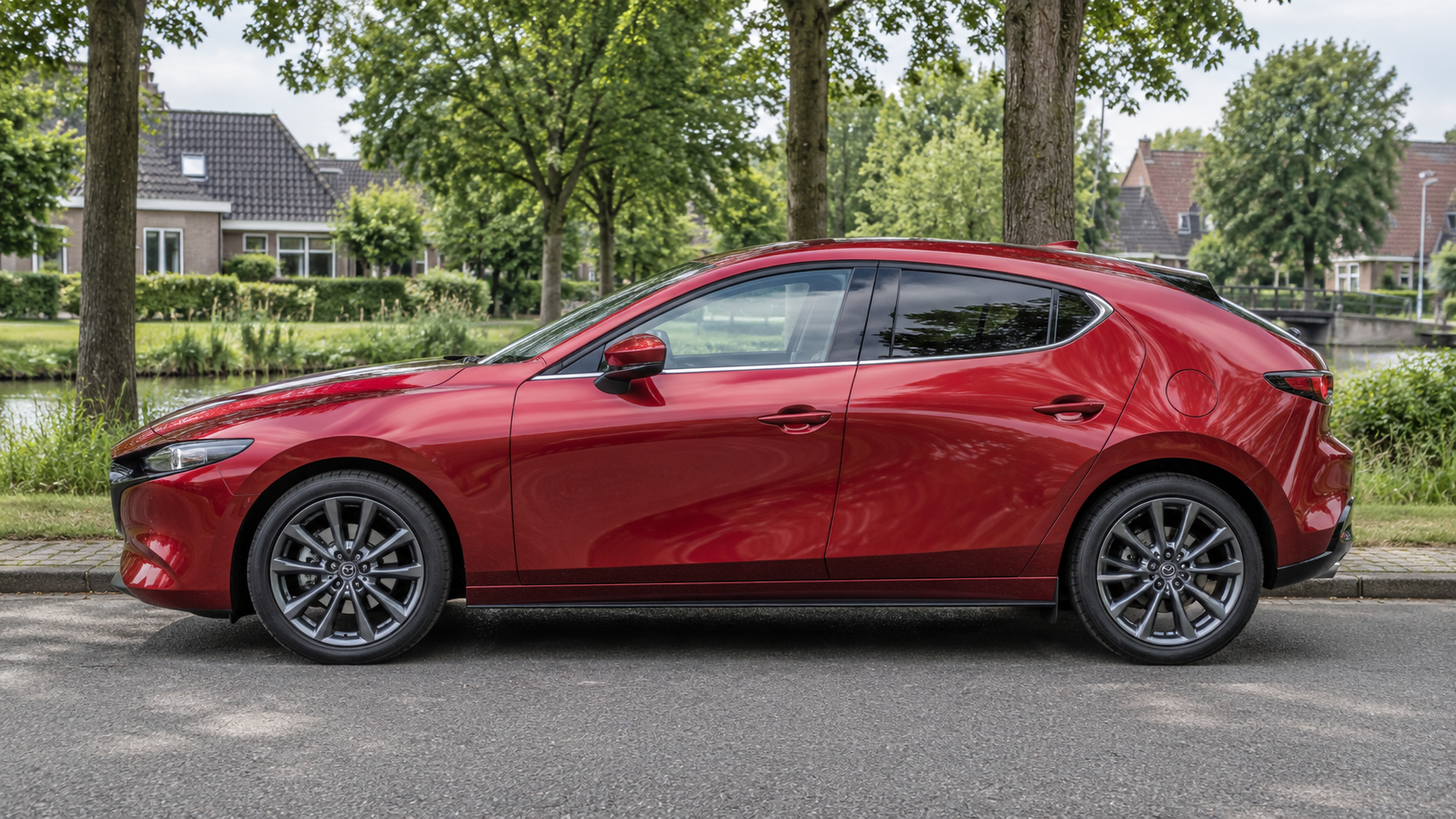 Rode Mazda 3 hatchback van de vierde generatie in zijaanzicht