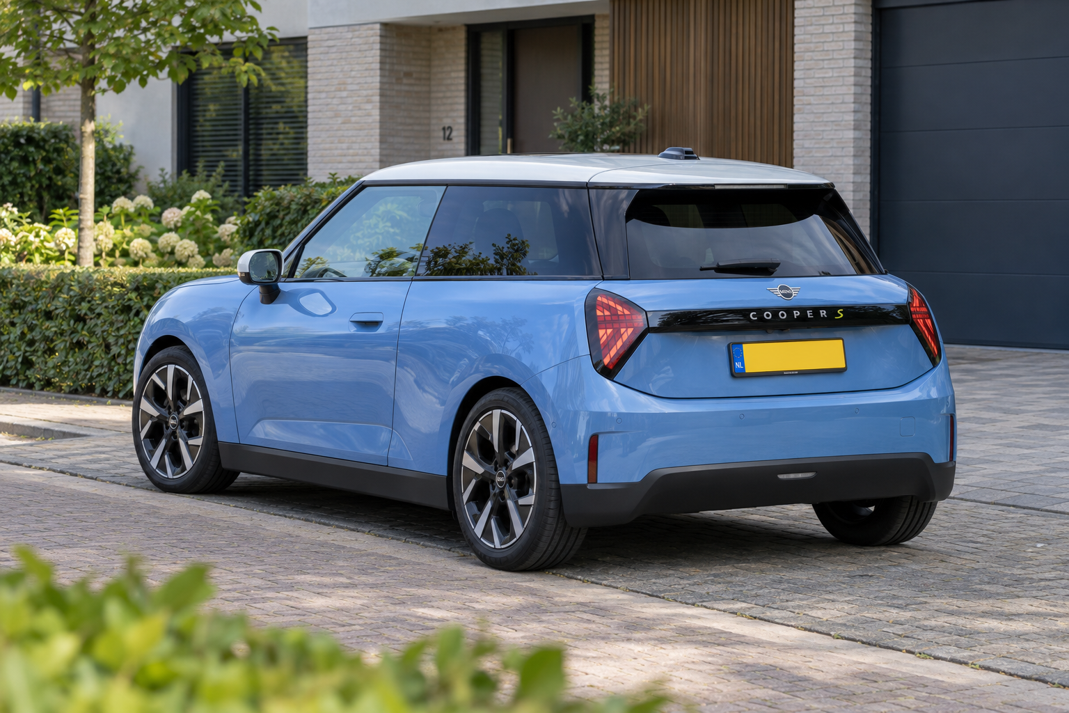 Blauwe elektrische MINI Cooper uit de nieuwere generatie met kenmerkende achterlichten