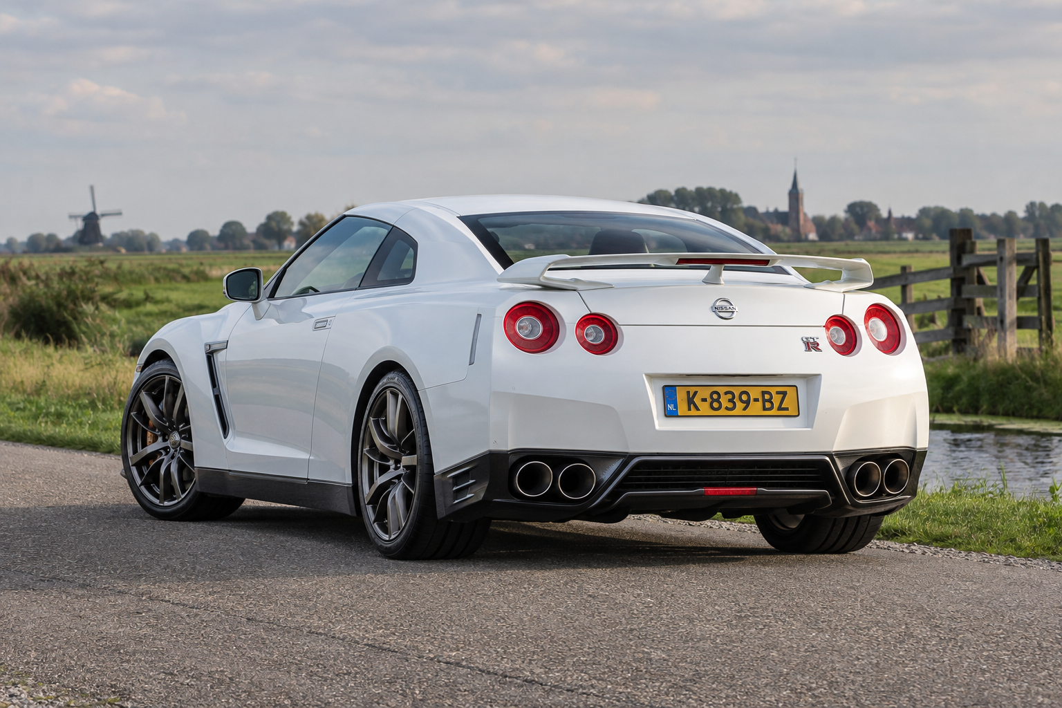 Illustratie van een Nissan GT-R R35 schuin van achteren met de vier ronde achterlichten