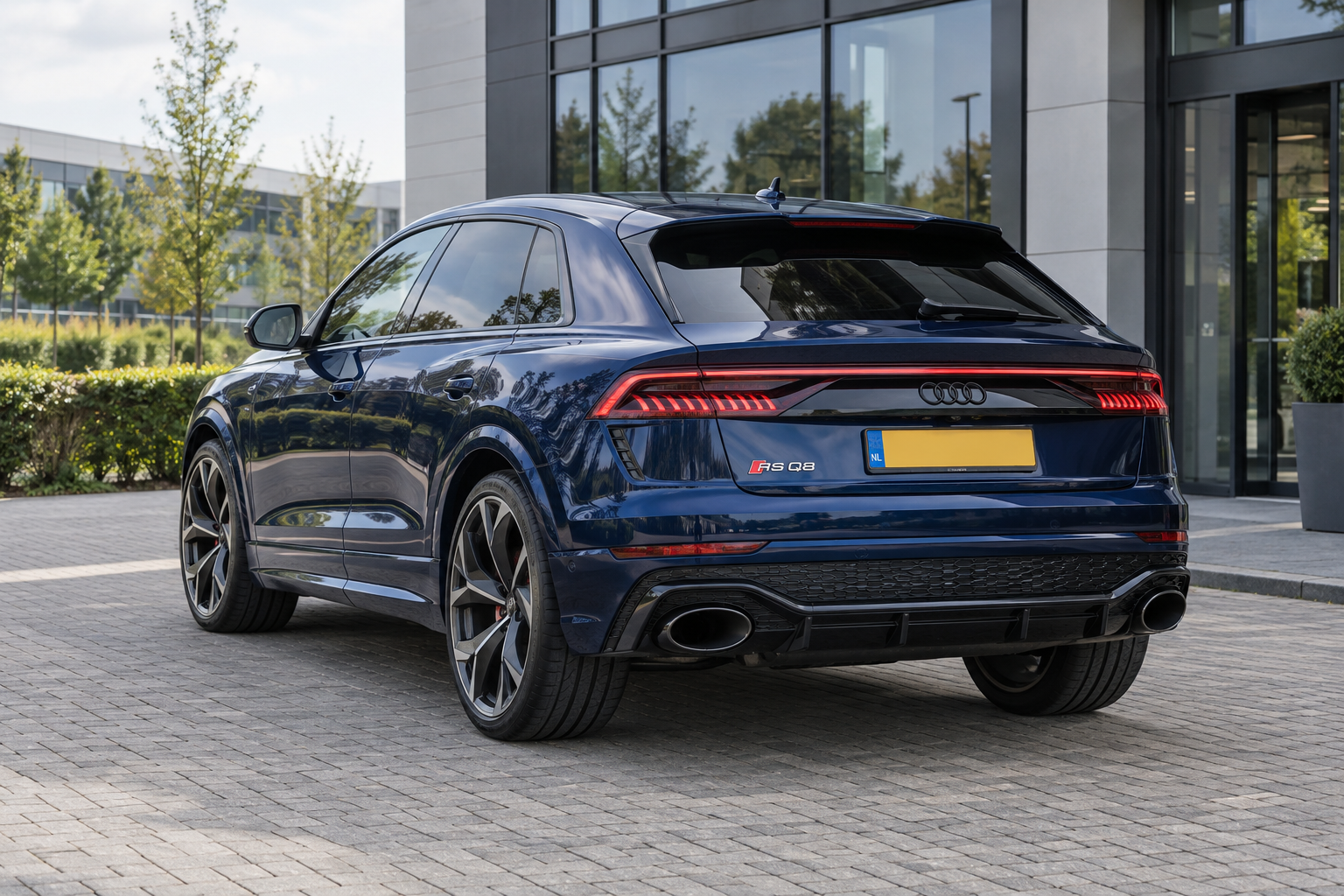 Blauwe Audi RS Q8 als modelillustratie, met de coupé-achtige SUV-daklijn van achteren gezien