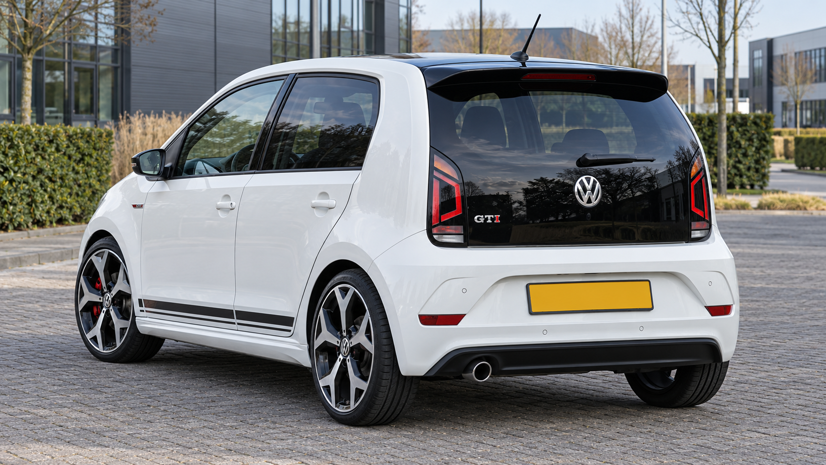 Witte vijfdeurs Volkswagen up! GTI van achteren met zwarte glazen achterklep en GTI-badge
