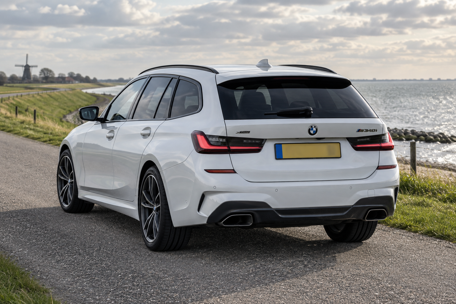 Witte BMW M340i Touring langs een Nederlandse dijk