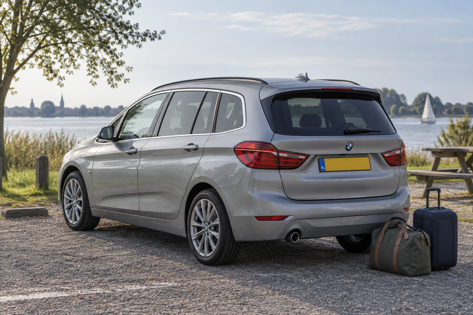 BMW 2 Serie Gran Tourer F46 met lange daklijn bij het water, met weekendtassen naast de auto