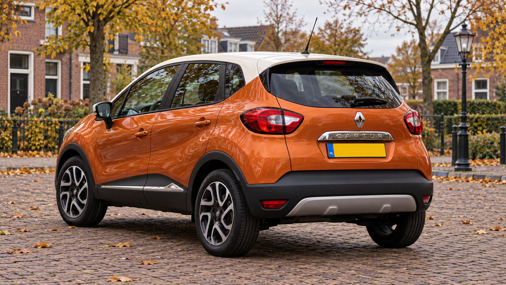 Oranje Renault Captur van de eerste generatie met ivoorkleurig dak, van achteren