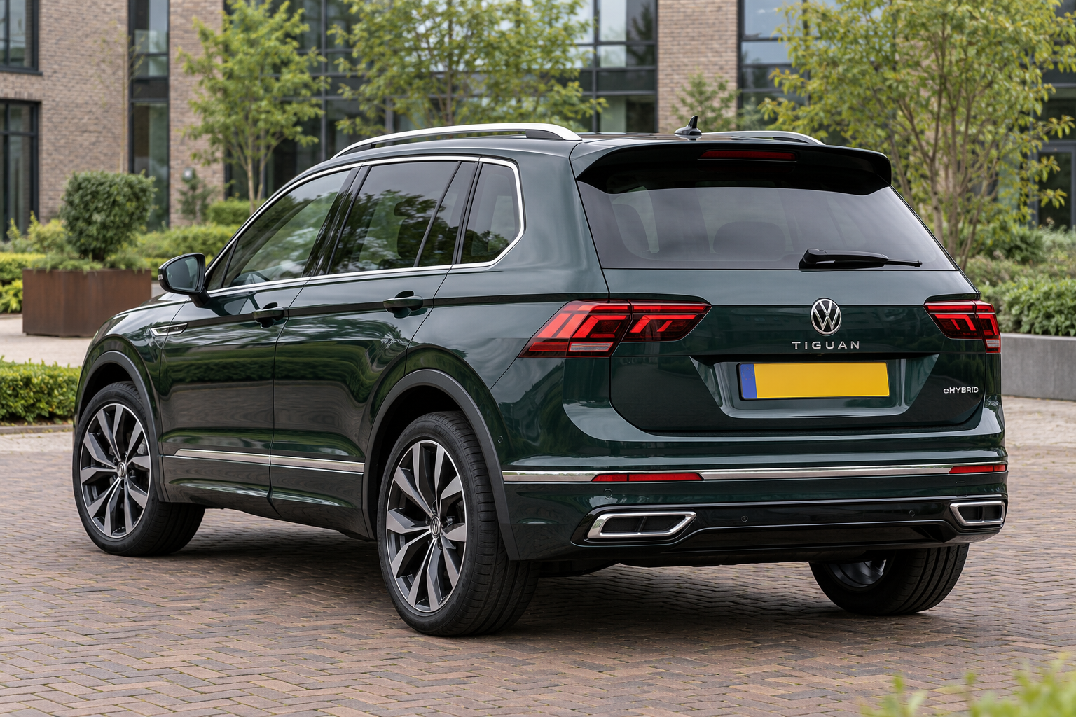 Groene eerdere Volkswagen Tiguan eHybrid van achteren, met gescheiden achterlichten